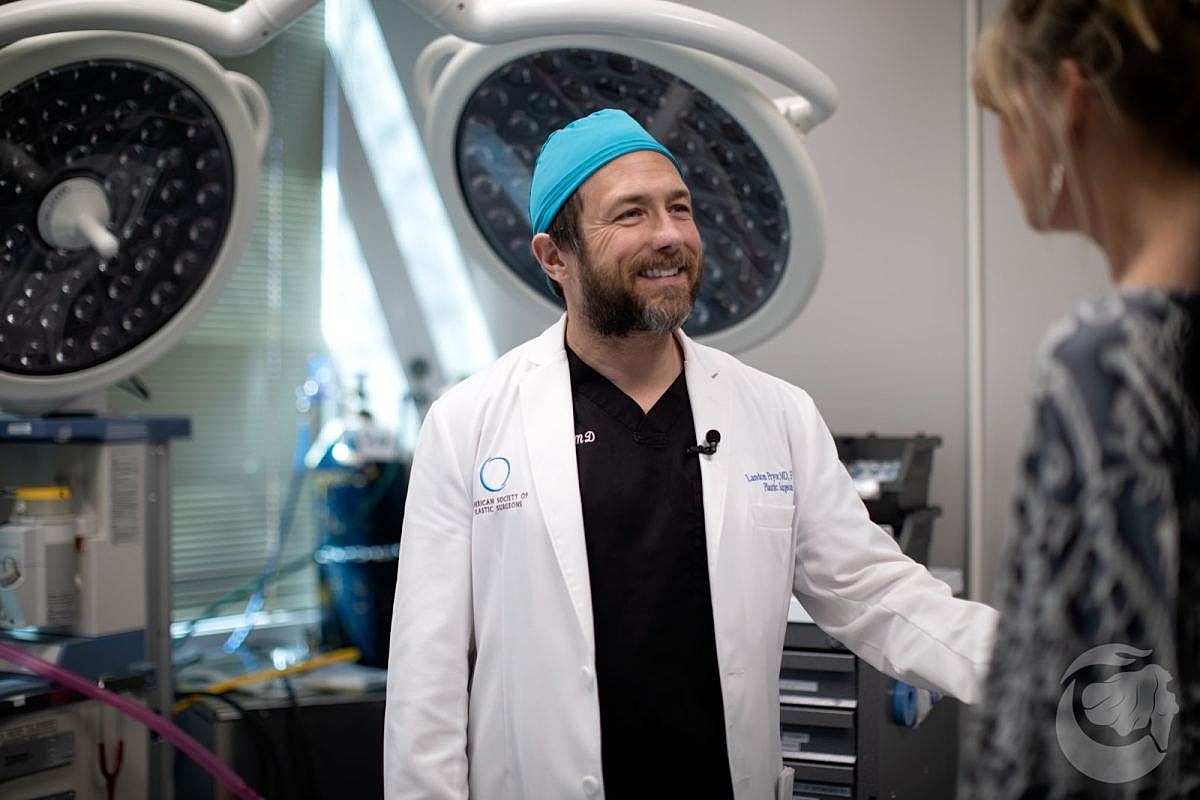 Doctor smiling in operating room, engaging with patient.