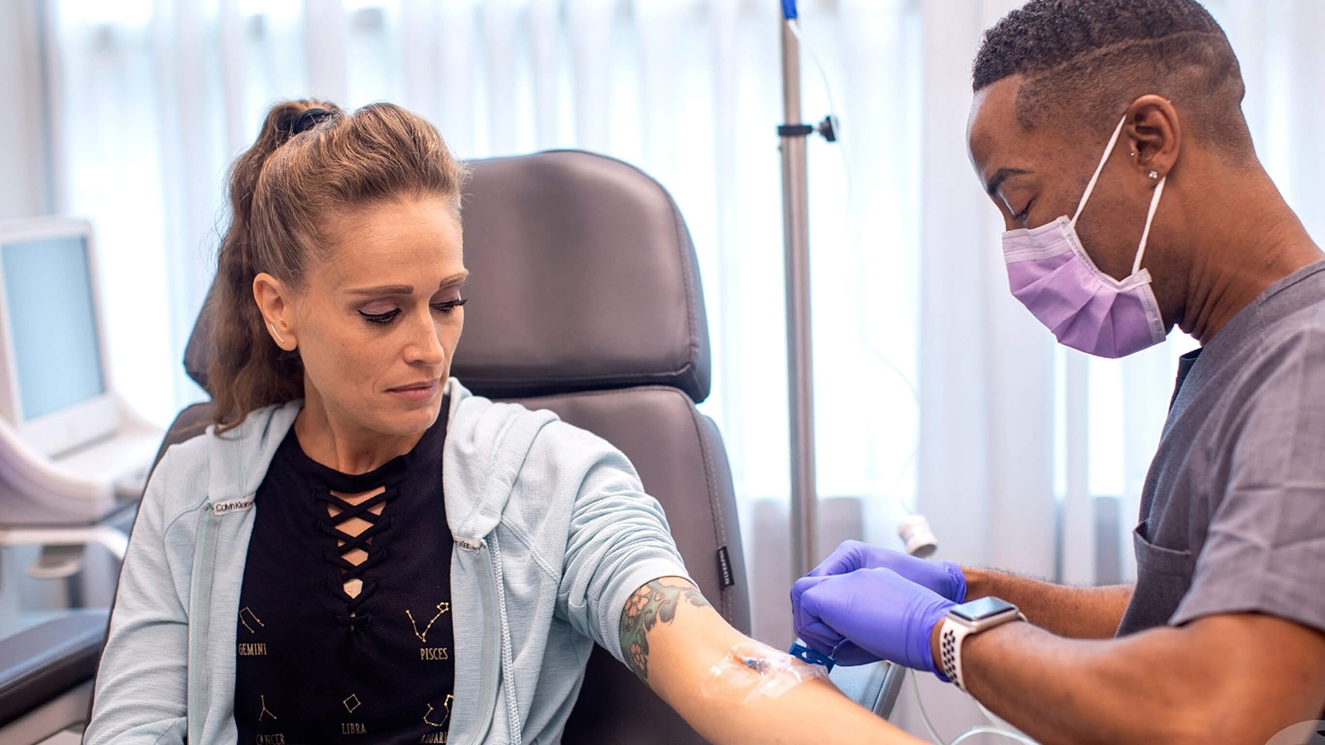 Patient receiving intravenous treatment in medical setting.